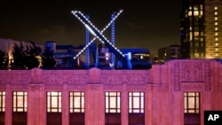 FILE - Workers install lighting on an "X" sign atop the company headquarters, formerly known as Twitter, in downtown San Francisco, July 28, 2023.