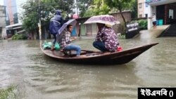 রাজশাহীতে রেকর্ড বৃষ্টির কারণে কোথাও কোথাও যানবাহনের পরিবর্তে নৌকায় করে চলাচল করছে মানুষ। ৪ অক্টোবর, ২০২৩।