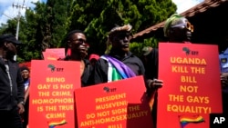 FILE - Activists hold placards during their picket against Uganda's anti-homosexuality bill at the Ugandan High Commission in Pretoria, South Africa, Apr. 4, 2023. 