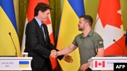 Presiden Ukraina Volodymyr Zelenskyy dan Perdana Menteri Kanada Justin Trudeau berjabat tangan saat konferensi pers setelah pembicaraan mereka di Kyiv, 10 Juni 2023. (Foto: AFP)