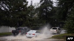 Vehicles drive down a flooded roadway due to severe rain in Los Angeles, California, on Feb. 25, 2023.