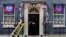 A worker carries a ladder past England bunting and flags outside 10 Downing Street in London on Aug. 18, 2023, ahead of England playing against Spain on Sunday in the final of the Women's World Cup. 