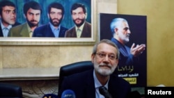 FILE - Iranian parliament speaker Ali Larijani attends a news conference at the Iranian embassy in Beirut's southern suburbs, as a picture of late Iran's Quds Force top commander Qassem Soleimani is seen in the background, Lebanon February 17, 2020.