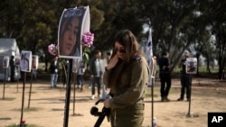ทหารหญิงของอิสราเอลรายนี้ยืนร้องไห้ต่อหน้ารูปภาพของผู้ที่ลักพาตัวไปโดยฮามาส ระหว่างการโจมตีรุนแรงเข้าใส่อิสราเอล .