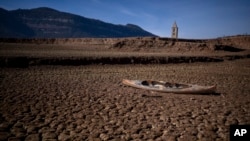 Напуштено кану седи на испукана земја среде суша во акумулацијата Сау, северно од Барселона, Шпанија, 22 јануари 2024 година.