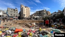 Palestinians inspect a debris field following an Israeli raid at Kamal Adwan hospital, amid the ongoing conflict between Israel and Palestinian Islamist group Hamas, in the northern Gaza Strip, Dec. 16, 2023.