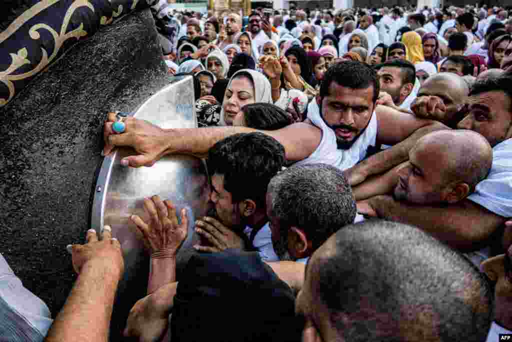 Muslim worshippers approach to kiss and touch the Hajar al-Aswad, or &quot;Black Stone,&quot; a rock set into the eastern corner of the Kaaba,&nbsp;which is believed to be the only piece remaining from an altar built by the patriarch Abraham, at the Grand Mosque in Saudi Arabia&#39;s holy city of Mecca. (Photo by Sameer Al-DOUMY / AFP)