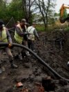 Municipal workers pump water from a crater after a Russian attack on mental hospital №3 in Kharkiv, Ukraine, April 27, 2024. Russian drones early Sunday also struck the Black Sea city of Mykolaiv. 