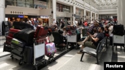 People sit near their luggage at the Beirut–Rafic Hariri International Airport, in Beirut, Lebanon, July 29, 2024.
