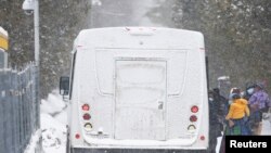 FILE - Pencari suaka menaiki bus setelah menyeberang ke Kanada dari AS di Champlain, New York, AS, 28 Februari 2023. (REUTERS/Christinne Muschi)