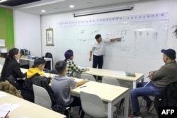 Instruktor predaje tradicionalno mongolsko pismo u školi u Ulan Batoru, glavnom gradu Mongolije, 19. oktobra 2020. Od 1. septembra 2023. u susednoj kineskoj provinciji Unutrašnja Mongolija, mandarinski se smatra jedinim jezikom nastave za svim predmetima.