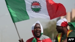 FILE - A protester waves a flag of the Nigerian Labour Congress during a protest in Abuja, Feb. 27, 2024. Labor unions in Nigeria began an indefinite strike June 3, 2024, in pursuit of a new minimum-wage deal.