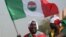 FILE - A protester waves a flag of the Nigerian Labour Congress during a protest in Abuja, Feb. 27, 2024. Labor unions in Nigeria began an indefinite strike June 3, 2024, in pursuit of a new minimum-wage deal.