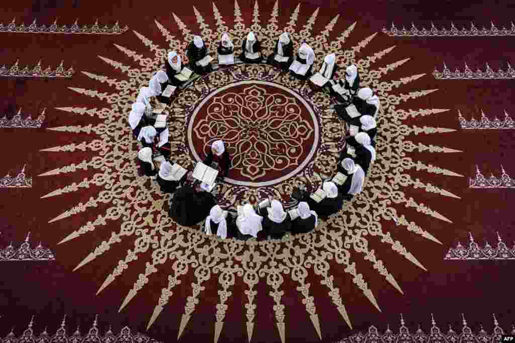 Palestinian Muslim girls sit together in a circle at a class for the recitation of the Quran, Islam&#39;s holy book, during a summer camp at a mosque in Gaza city.