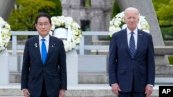 ARCHIVO - El primer ministro japonés Fumio Kishida y el presidente estadounidense Joe Biden, a la derecha, reaccionan después de colocar una ofrenda floral en el Parque Conmemorativo de la Paz de Hiroshima, Japón, el 19 de mayo de 2023, durante la Cumbre del G7.