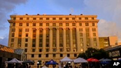 Media vehicles stage outside the Fulton County Courthouse, Atlanta, Aug. 14, 2023, in Atlanta. 