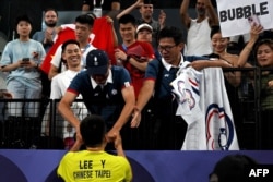 Taiwan's Lee Yang celebrates with supporters in the audience as he exits the court after winning the men's doubles badminton final match against China during the Paris 2024 Olympic Games at Porte de la Chapelle Arena in Paris on Aug. 4, 2024.