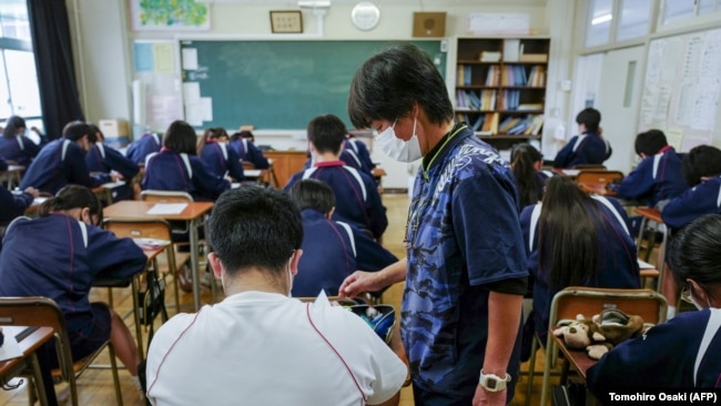 Seorang guru sedang berbincang dengan salah seorang murid di sebuah kelas di Tokyo, 22 November 2022. (Foto: Kazuhiro Nogi/AFP)