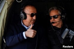 Turkish Foreign Minister Mevlut Cavusoglu gestures as he sits in a helicopter with U.S. Secretary of State Antony Blinken for a tour of earthquake stricken areas of Hatay Province, at Incirlik Air Base near Adana, Turkey, Feb. 19, 2023.