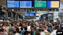 Hành khách tập trung quanh bảng thông báo tại ga tàu Gare Montparnasse ở Paris vào ngày 26/7/2024 khi mạng lưới đường sắt cao tốc của Pháp bị tấn công.