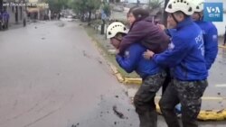 কুইটোতে বন্যার পানিতে ডুবে যাওয়া রাস্তায় বাসিন্দাদের সাহায্য করছে পুলিশ