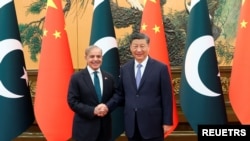 资料照片：中国国家主席习近平在北京人民大会堂同巴基斯坦总理谢里夫握手。(2024年6月7日)