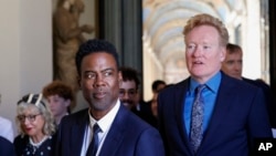 Chris Rock, left, and Conan O'Brien arrive for an audience with Pope Francis in the Clementine Hall at the Vatican, June 14, 2024. 