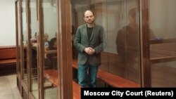 (FILE) Russian opposition figure Vladimir Kara-Murza stands inside an enclosure for defendants during a court hearing in Russia.