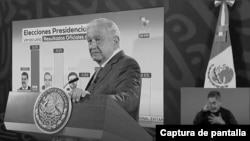 Captura de pantalla de YouTube en blanco y negro de la conferencia de prensa del presidente Andrés Manuel López Obrador del 29 de julio de 2024, donde muestra los supuestos resultados de las elecciones de Venezuela, las cuales contienen un error. 