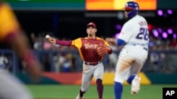 Los jugadores de Venezuela reciben a Anthony Santander (25) tras conectar un jonrón en el primer inning ante Puerto Rico en el Clásico Mundial de béisbol, el domingo 12 de marzo de 2023 en Miami. (AP Foto/Wilfredo Lee)