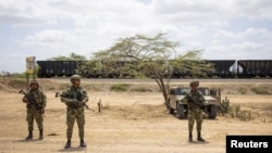 ARCHIVO - Soldados montan guardia cerca de los vagones de tren cargados de carbón, antes de que los indígenas wayuu de las comunidades cercanas levantaran un bloqueo de una línea férrea en Puerto Bolívar, Colombia, el 7 de abril de 2023.