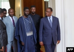 This handout photo distributed by the Senegalese presidential palace on March 28, 2024 shows President-elect Basilou Diomaye Faye (third from right) and outgoing President Macky Sall (right) in Dakar Meeting at the Presidential Palace.