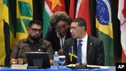 Barbados Prime Minister Mia Mottley, center, talks to Guyana's President Irfaan Ali, left, and Jamaica's Prime Minister Andrew Holness during an emergency Caribbean Community bloc meeting on Haiti in Kingston, Jamaica, on March 11, 2024.