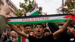 Protesters hold flags and shout slogans gather for a pro-Palestinian rally in Rome, Oct. 21, 2023. 