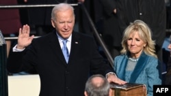 Rais Joe Biden akiwa na mkewe Jill Biden wakati alipoapishwa na jaji John Roberts kuwa rais wa Marekani Januari 20, 2021. Picha na SAUL LOEB / POOL / AFP