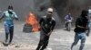 Protesters run for cover from tear gas fired by police during a protest against insecurity in Port-au-Prince, Haiti, Aug. 7, 2023. 