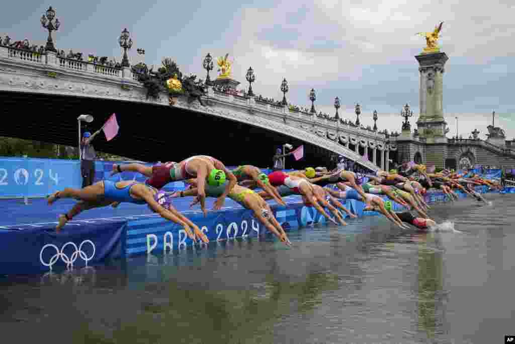 Para atlet menyelam ke dalam air untuk memulai kompetisi triatlon individu wanita di Olimpiade Musim Panas 2024 di Paris, Prancis. (AP)&nbsp;