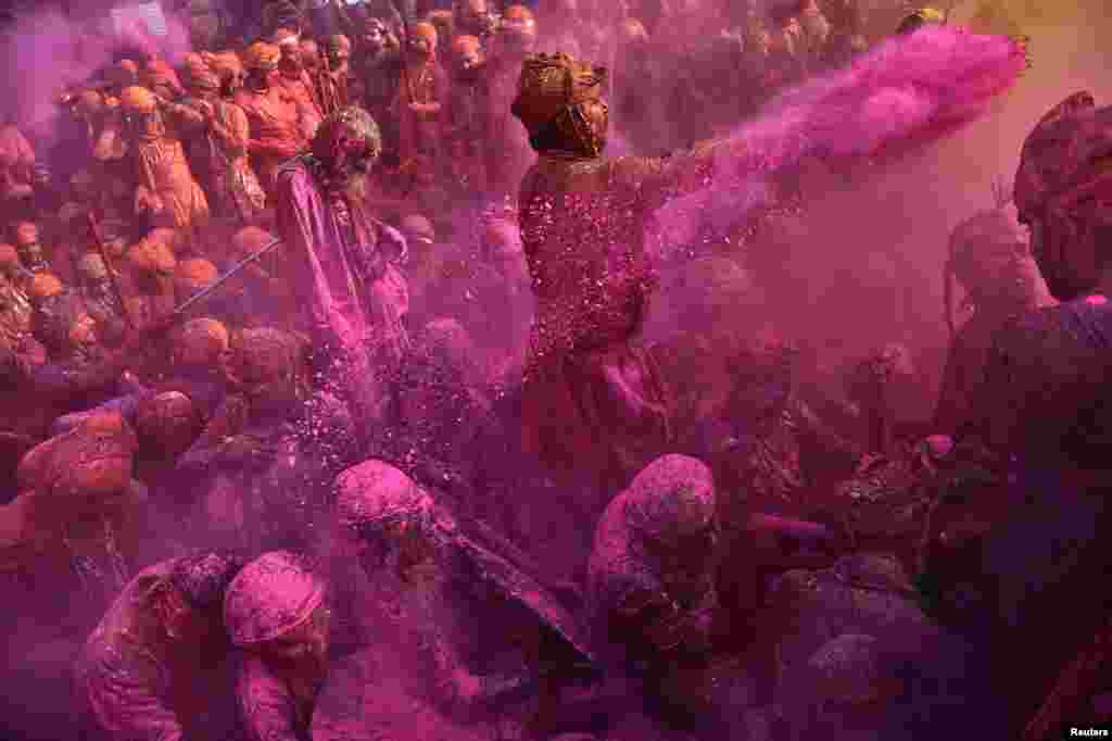 Hindu devotees take part in the religious festival of Holi inside a temple in Nandgaon village, in the state of Uttar Pradesh, India.