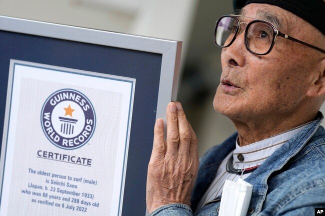 Seiichi Sano, an 89-year-old Japanese man who has been recognized by Guinness World Records as the oldest male to surf, shows his Guinness certificate at Katase Beach, Thursday, March 30, 2023, in Fujisawa, south of Tokyo. (AP Photo/Eugene Hoshiko)