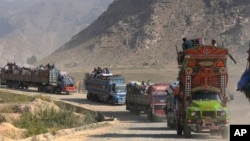 FILE - A convey of trucks carrying Afghan families drive toward a border crossing point in Torkham, Pakistan, Oct. 31, 2023.