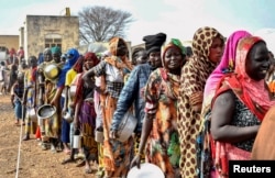 FILE - Women who fled the war-torn Sudan queue to receive food rations at the UNHCR transit center in Renk, near the border crossing point in Renk County of Upper Nile State, South Sudan, May 1, 2023.