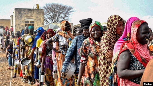 FILE - Women who fled the war-torn Sudan queue to receive food rations at the United Nations High Commissioner for Refugees (UNHCR) transit centre in Renk, near the border crossing point in Renk County of Upper Nile State, South Sudan May 1, 2023.