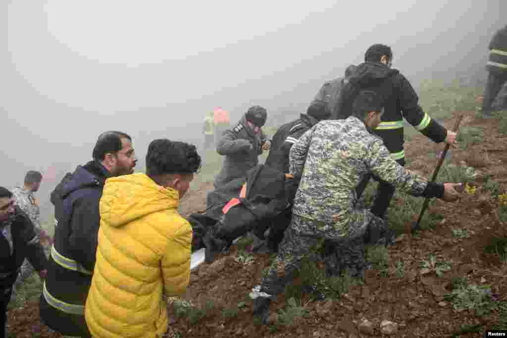 Спасувачкиот тим носи тело по падот на хеликоптерот во кој се превезувал иранскиот претседател Ебрахим Раиси, во Варзакан, провинцијата Источен Азербејџан. (Стрингер/ВАНА (Новинска агенција за Западна Азија))