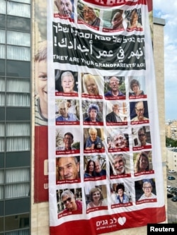 A giant sign depicting the faces of elderly people who are missing and believed to be in Gaza following the infiltration of Israel by Hamas gunmen hangs on a home for older people in Netanya, Israel, Oct. 27, 2023.