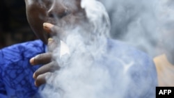 FILE - A man smokes cannabis popularly known as marijuana in Lagos, Nov. 11, 2019. The country's National Drug Law Enforcement Agency said over 14 million Nigerians use illegal drugs. The majority use locally-grown cannabis.