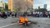 Un grupo de ciudadanos participa en una protesta contra los resultados de las elecciones presidenciales y queman restos de propaganda electoral, el lunes 29 de julio en Venezuela. 