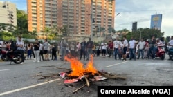 Un grupo de ciudadanos participa en una protesta contra los resultados de las elecciones presidenciales y queman restos de propaganda electoral, el lunes 29 de julio en Venezuela. 