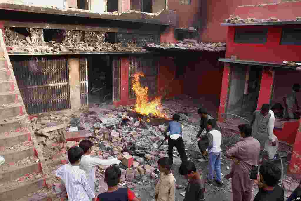 Youngsters look a church damaged and burned by angry Muslim mob in Jaranwala near Faisalabad, Pakistan, Aug. 16, 2023.