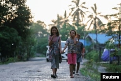 Anak-anak suku Balik berjalan di sepanjang jalan di desa mereka, yang terletak di dekat ibu kota baru Indonesia, IKN, di Sepaku, Kalimantan Timur, 6 Maret 2023. (REUTERS/Willy Kurniawan)