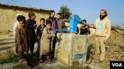 پانی پراجیکٹ کے فاؤنڈر سنی خان پاکستان میں ایک پراجیکٹ پر بچوں کے ساتھ نلکا چلاتے ہوئے ۔